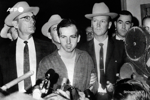 Lee Harvey Oswald (C) présenté à la presse à Dallas, le 22 novembre 1963 - AFP