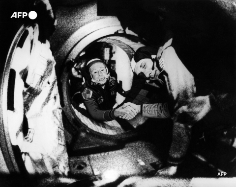 Le commandant du vaisseau soviétique Soyouz, Alexei Leonov (G) et le commandant de l'équipage américain d'Apollo, Thomas Stafford (D), se serrent la main le 17 juillet 1975 dans l'espace, quelque part au-dessus de l'Allemagne de l'Ouest - AFP