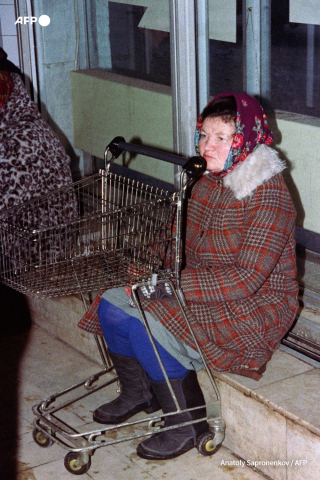 Une Moscovite est assise devant son chariot vide le 18 janvier 1992. - Anatoly Sapronenkov - AFP