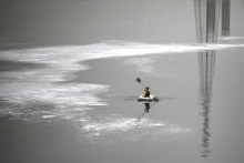 A boy rows a boat across the polluted waters of river Yamuna laden with foam, on a hot summer day in New Delhi on June 9, 2022. Money SHARMA / AFP